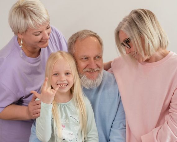 A joyful multigenerational family poses and smiles together indoors, showcasing love and togetherness.